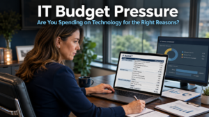 Business owner reviewing a technology budget and software spending plan on a laptop in a modern office, representing the challenge of IT budget pressure and making smart technology decisions
